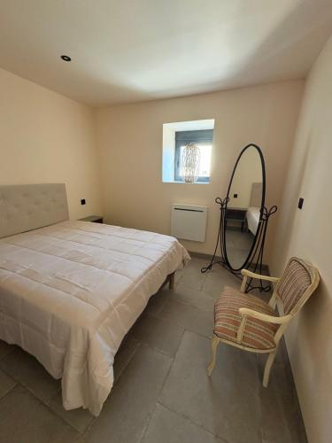 a bedroom with a bed and a mirror and a chair at gite 8 pers avec SPA MARBOZ in Marboz