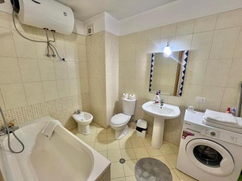 a bathroom with a toilet a sink and a washing machine at Casa del Mar 2-Sea view Vollga, 2BR in Durrës