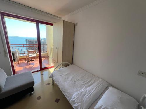 a bedroom with a bed and a balcony with a table at Casa del Mar 2-Sea view Vollga, 2BR in Durrës