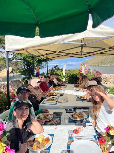a group of people sitting at a table eating food at Puma Punku Lodge in Isla Chillica