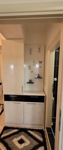 a white cabinet in a room with a rug at Lina Apartment in Bitola