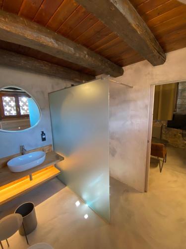 a bathroom with a sink and a glass wall at Cascina Belvedì in Clanezzo