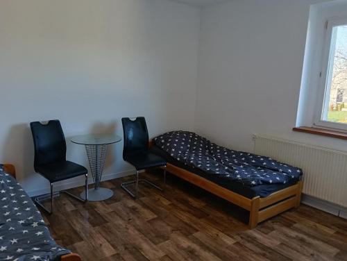 a bedroom with a bed and two chairs and a table at Noclegi Adam in Radonia