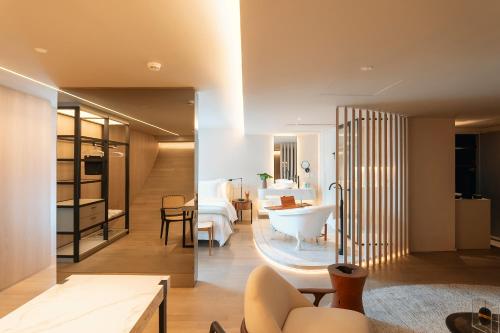 a living room with a tub and a bedroom at Hotel Unique in São Paulo