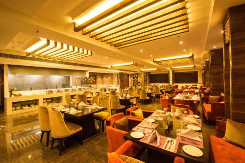 a dining room with tables and chairs and a restaurant at Regenta Central Amritsar in Amritsar