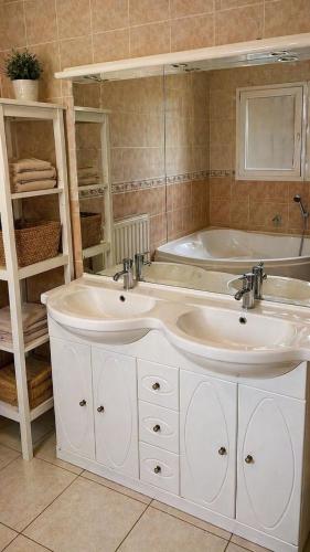 a bathroom with two sinks and a bath tub at PROVENCE, MAISON SPACIEUSE et CONFORTABLE à coté de SPIROU,NARUTO et , WAVE ISLAND in Monteux