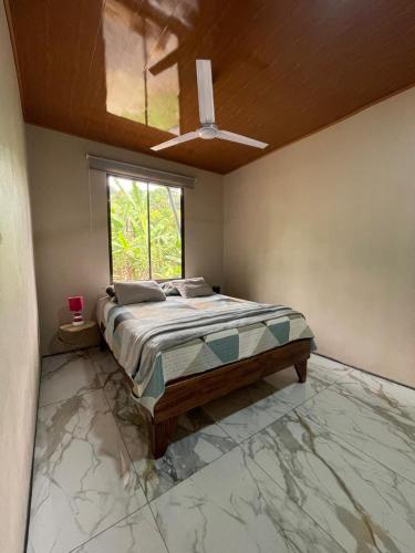 a bedroom with a bed and a window and a ceiling at Althi Mountain House in Naranjito