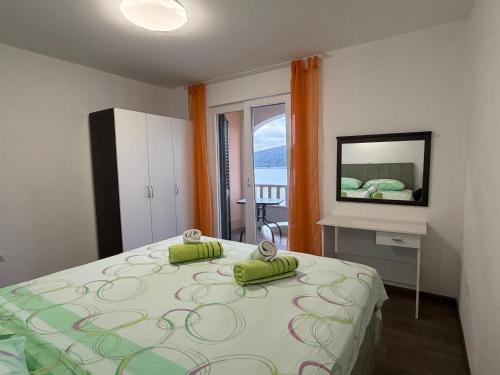 a bedroom with a bed with a television on the wall at Apartman 5 Majba in Zaglavice