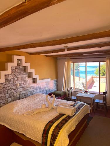 a bedroom with a large bed with a stone wall at Puma Punku Lodge in Isla Chillica