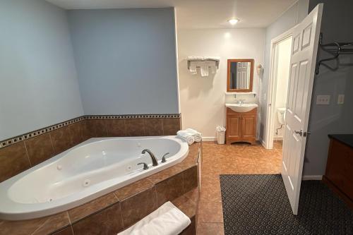 a large bathroom with a tub and a sink at At 9 Motel Near Freehold I-195 in Howell