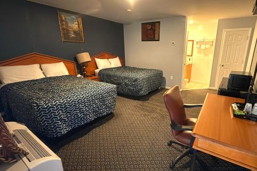 a hotel room with two beds and a desk at At 9 Motel Near Freehold I-195 in Howell
