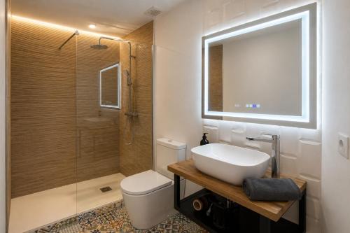 a bathroom with a toilet and a sink and a shower at Prime Suites Valencia in Valencia