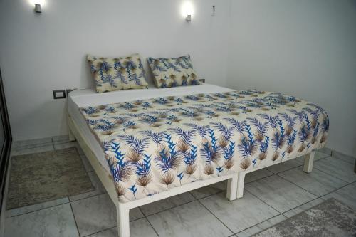 a bed with blue and white covers and pillows at BBS Maison in Douz