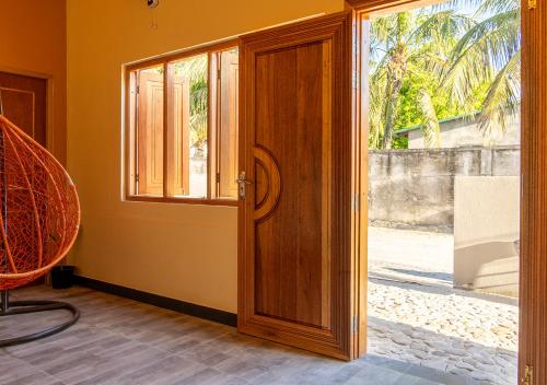 a wooden door with a window in a room at Sansara Maldives - The Untouched South, Easy Access via Sri Lanka in Meedhoo
