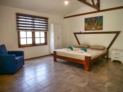 a bedroom with a bed and a blue chair at Kidrak Camping NAMASTE in Faralya