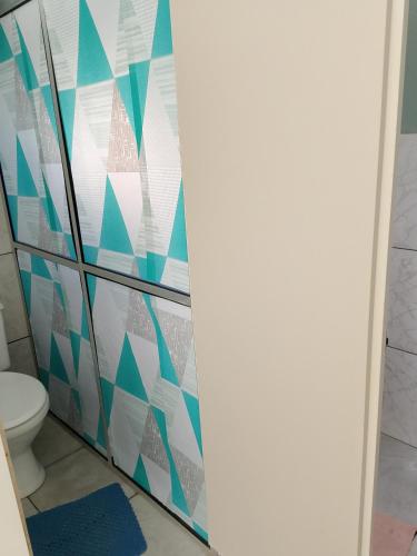 a bathroom with a toilet and blue and white tiles at Hostel Uziel in Timbó