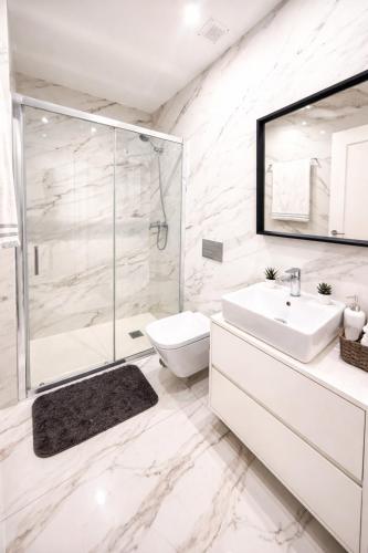 a white bathroom with a shower and a toilet and a sink at Cc House Porto in Porto