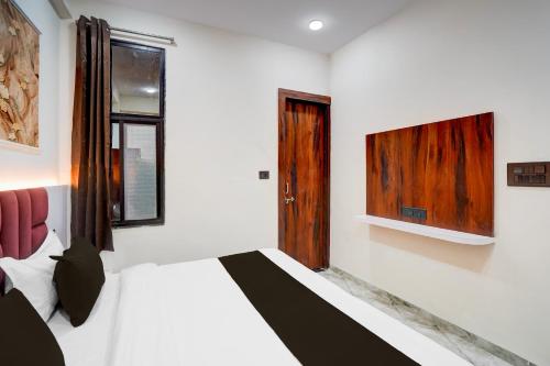 a bedroom with a bed and a tv on the wall at Hotel O S.P Residency in Indore