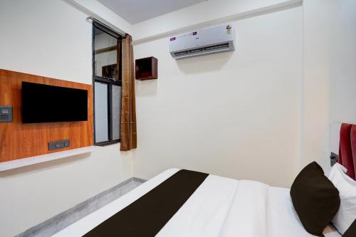 a bedroom with a white bed and a tv at Hotel O S.P Residency in Indore