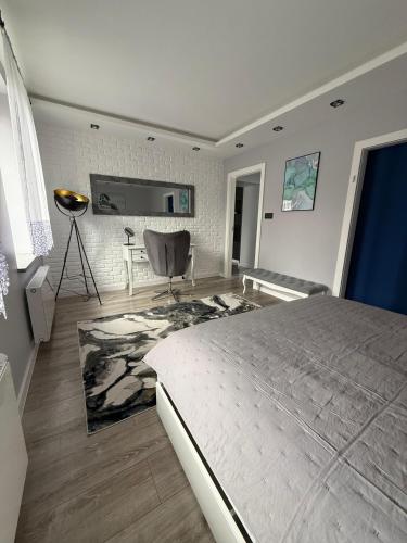 a bedroom with a bed and a chair in it at Modern Apart in Wałbrzych