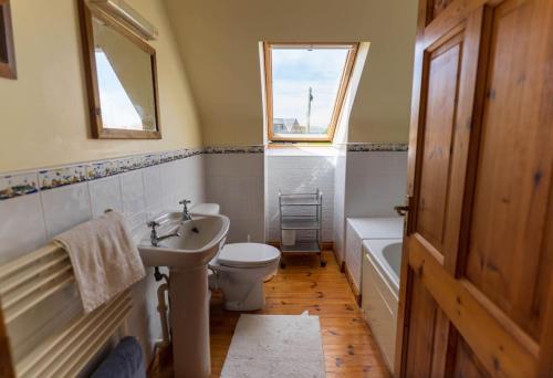 a bathroom with a sink and a toilet and a window at Lakehouse Waterville in Waterville