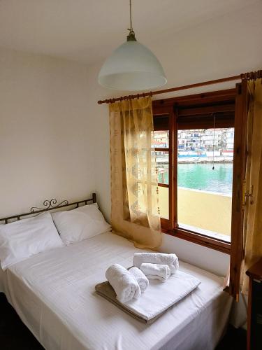 a bedroom with a bed with towels and a window at VintageVilla in Skala Marion