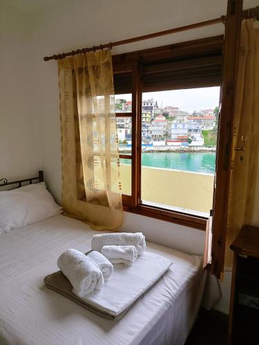 a bedroom with a window with towels on a bed at VintageVilla in Skala Marion