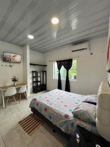 a bedroom with a bed and a table and a window at 301ElBunkerSuiteRomance in Arauca