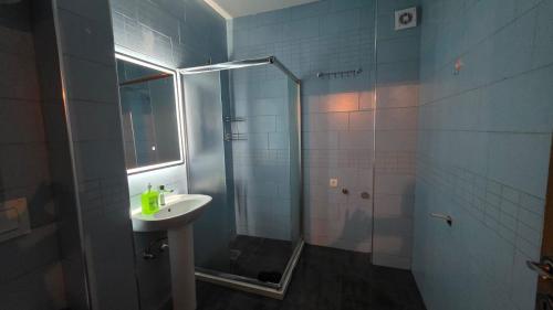 a bathroom with a sink and a shower at Art Apartment in Prizren