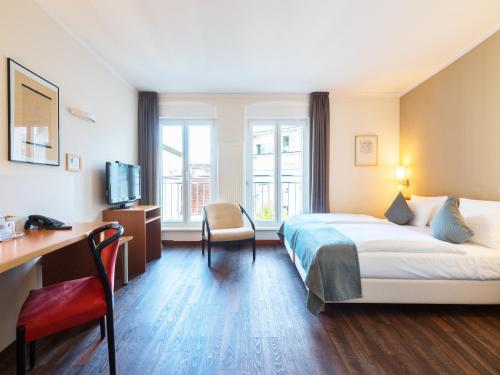 a hotel room with a bed and a desk at Hotel Leidinger - ehemalige Domicil und Domaine Leidinger in Saarbrücken