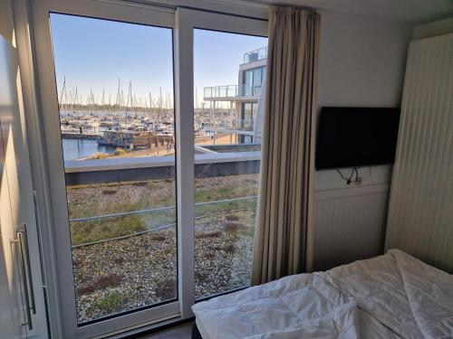 a bedroom with a bed and a window with a view at Ferienwohnung Austernfischer Marina Wendtorf in Wendtorf