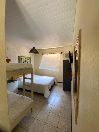a bedroom with two beds and a window at Maré Alta 400 mt da praia de Maresias in Maresias