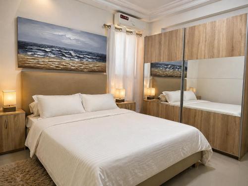 a bedroom with two beds and a painting on the wall at Modern Central Studio - Dakar Plateau in Dakar