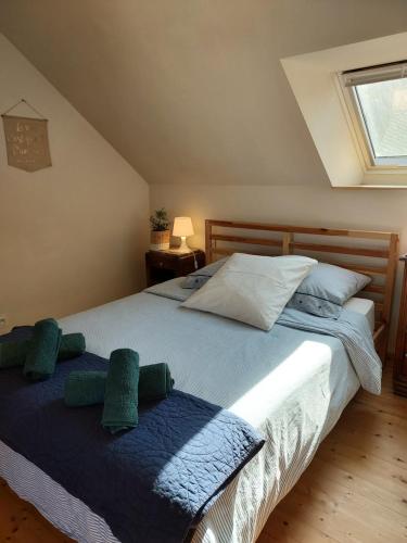 a bedroom with a large bed with green pillows at Gîte Baumelin près de Dinan in Guenroc