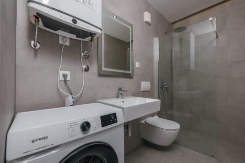 a bathroom with a washing machine and a sink at Luxury Apartment Bar in Šušanj