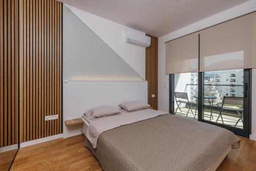 a bedroom with a bed and a large window at Luxury Apartment Bar in Šušanj