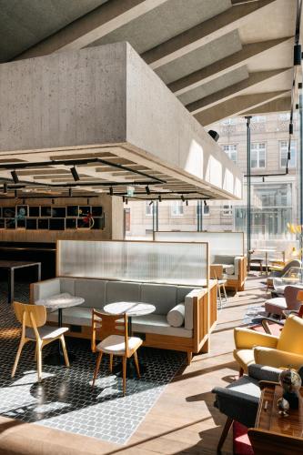 a lobby with tables and chairs in a building at Ruby Luna Hotel Dusseldorf by IHG in Düsseldorf