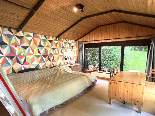 ein Schlafzimmer mit einem Bett und einer farbenfrohen Wand in der Unterkunft Datscha in Eutin
