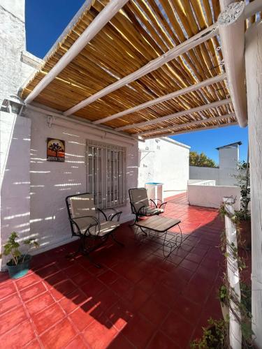 a patio with chairs and a wooden pergola at El depto de Bowie in Santa Rosa de Calamuchita