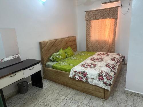 a small bedroom with a bed and a dresser at Hanover Hotels Suleja in Tunga Bai