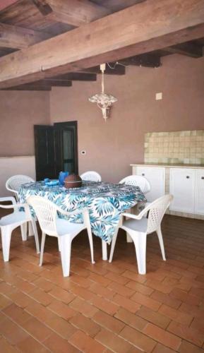 a dining room with a table and white chairs at Nerissa apartments in Terrasini