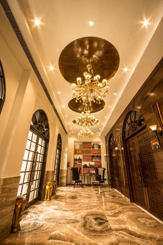 a large hallway with a chandelier and a dining room at Regenta Central Amritsar in Amritsar