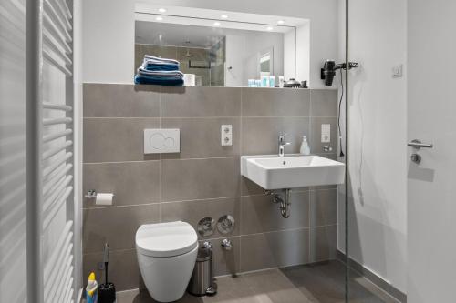 a bathroom with a toilet and a sink and a mirror at Loftbude in Hürth