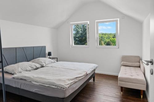 a white bedroom with a bed and a window at Loftbude in Hürth