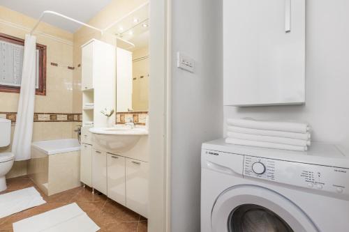 a bathroom with a washing machine and a sink at Apartments Carmen in Matulji