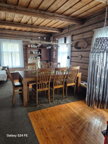 a dining room with a wooden table and chairs at Erämökki Puruveden rannalla in Vaara