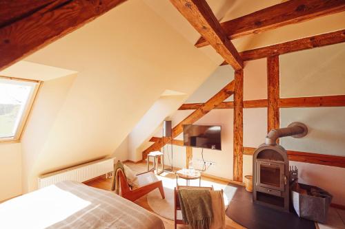 a bedroom with a wood stove in a attic at Feriendomizil Alter Garten in Temmen-Ringenwalde