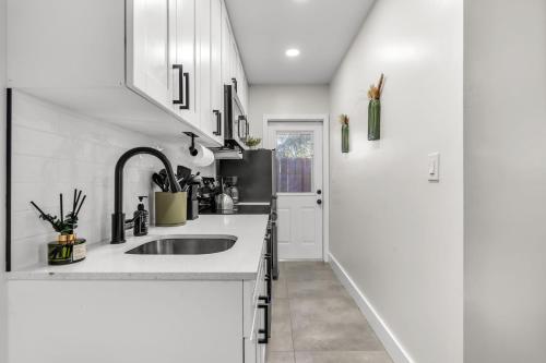 a kitchen with a sink and white cabinets at Bayview Apartments By Lowkl in Fort Lauderdale