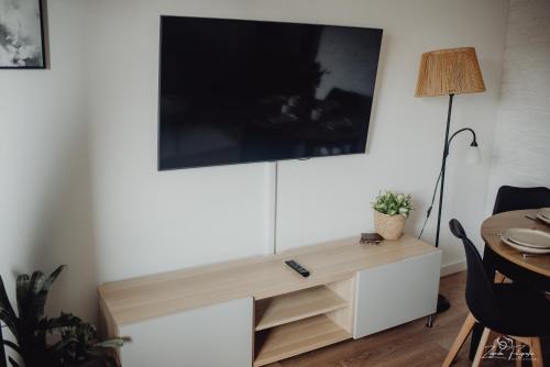 a living room with a tv on a wall at Mazurska przystań in Ryn