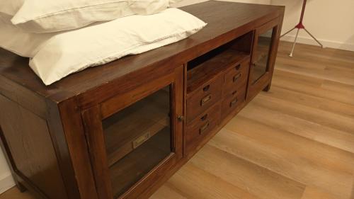 a wooden cabinet with glass doors and a bed at NaturalmenteLucia 2 in Cologno al Serio